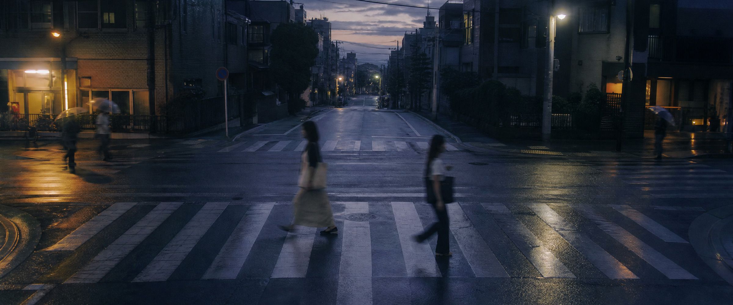 夕暮れの横断歩道ですれちがう人々